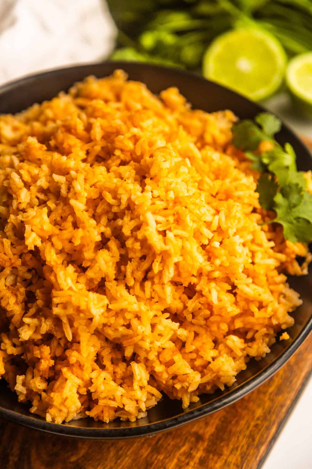 Mexican rice for tacos (simple Mexican rice recipe) in a bowl with cilantro and limes on the side.