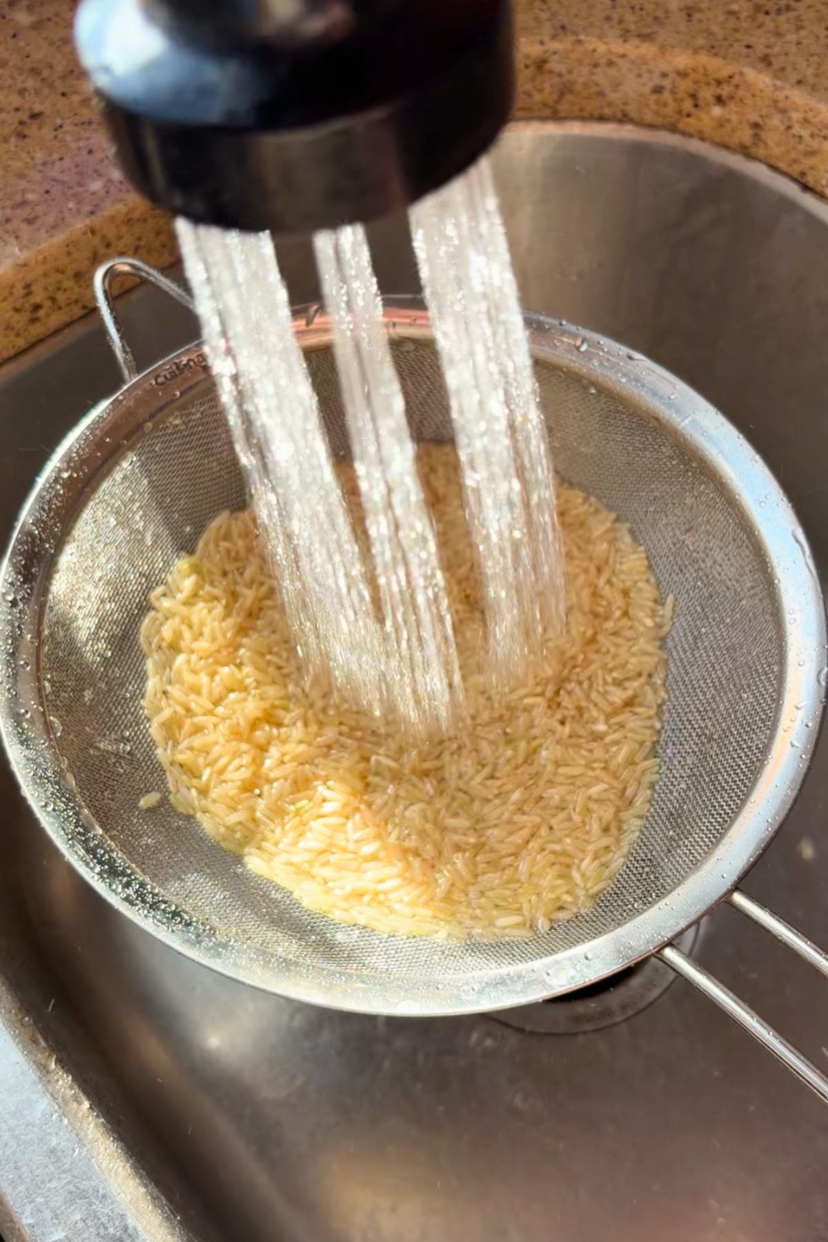 Rice rinsing in a strainer.