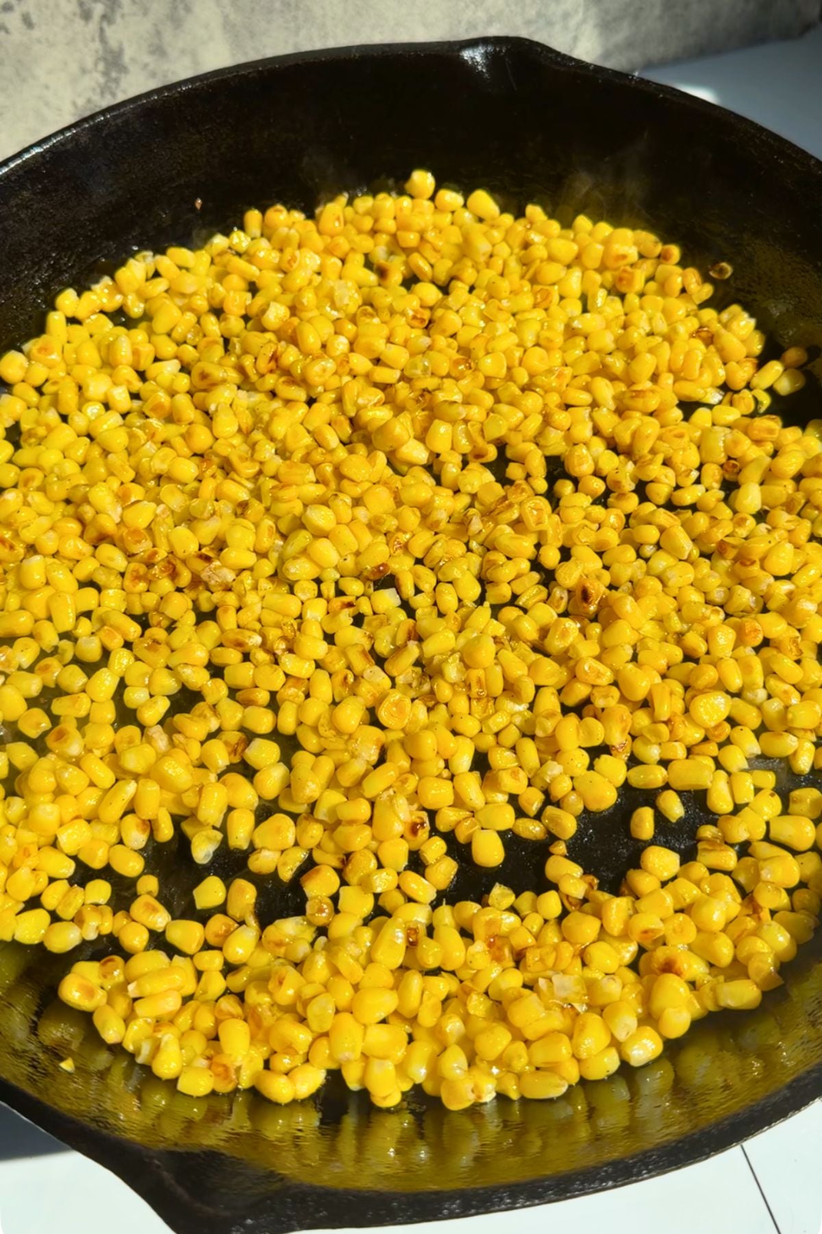 Frozen corn charring in a cast iron pan.