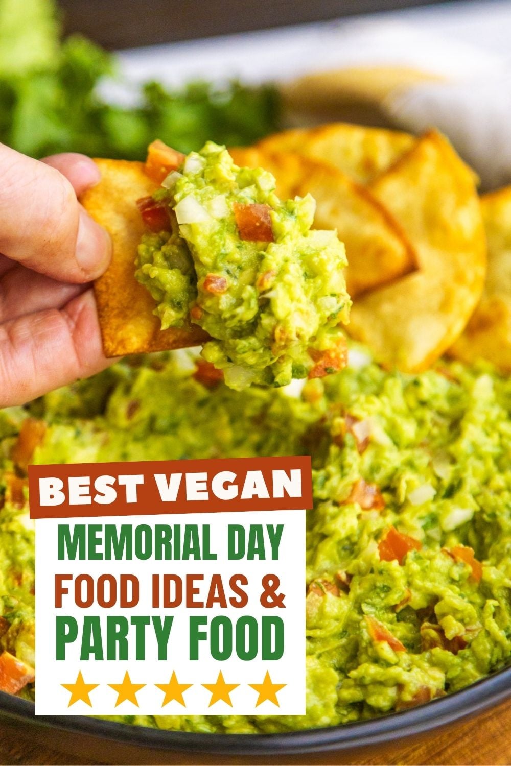 Guacamole in a black bowl with chips on the side.