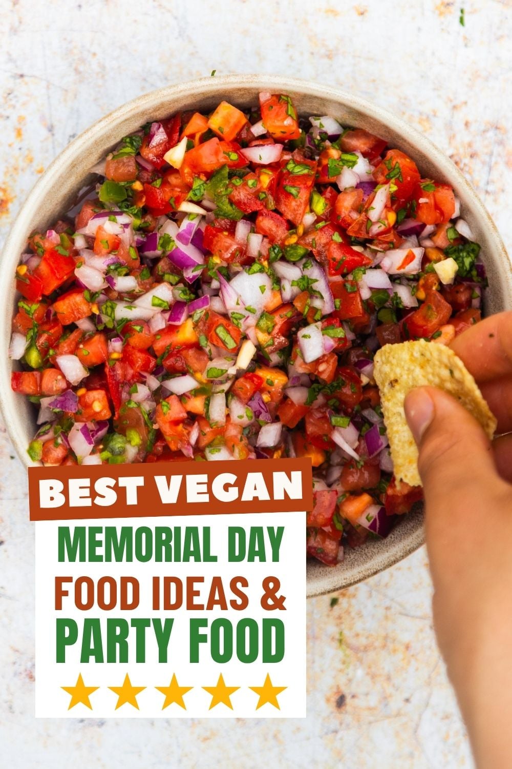 Pico de gallo in a bowl with a chip dipping in to it.