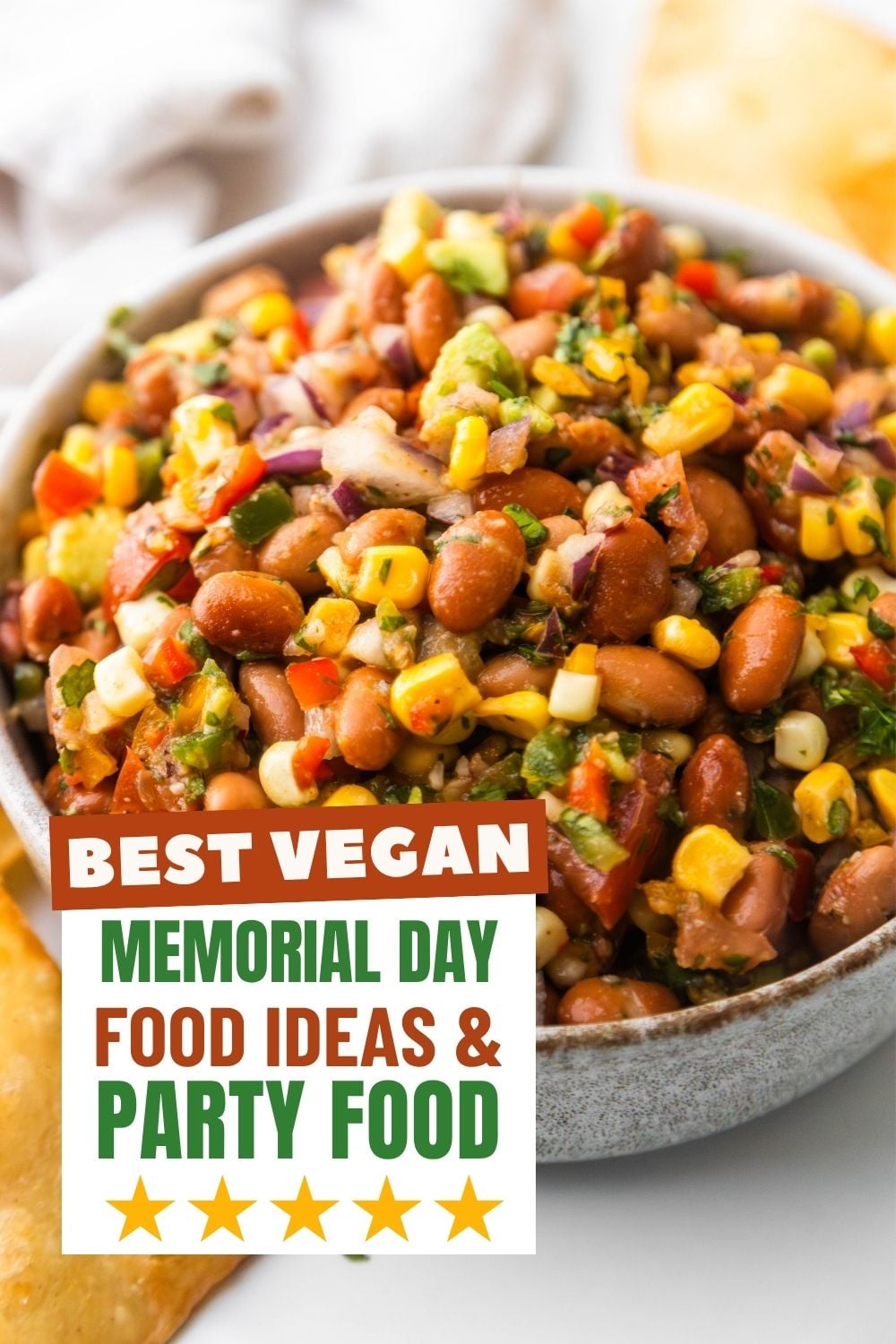 Pinto bean salad in a bowl with chips on the side.