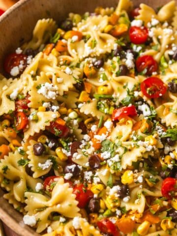 Southwest pasta salad in a bowl with salad spoons on the side.