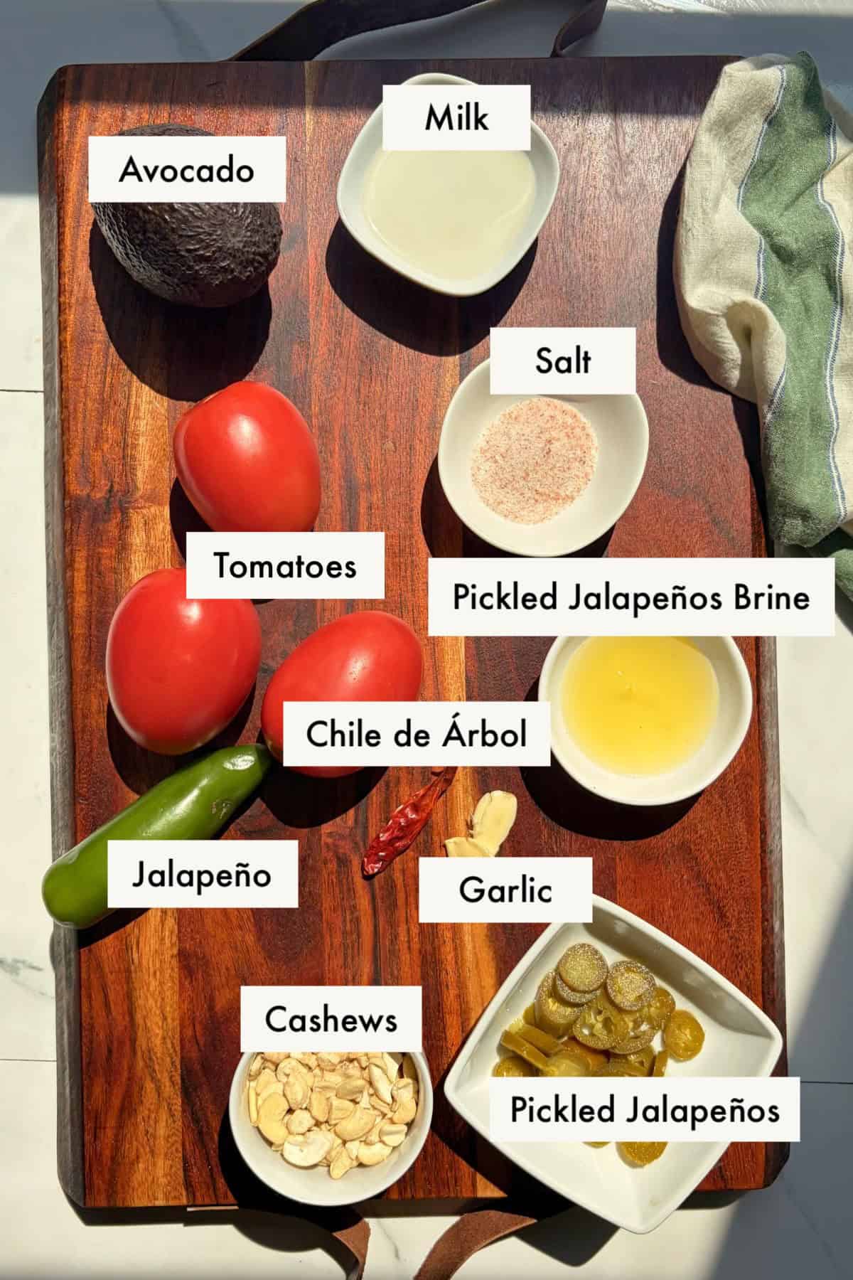 All ingredients for burrito bowl sauce recipe laid out on a wooden board.