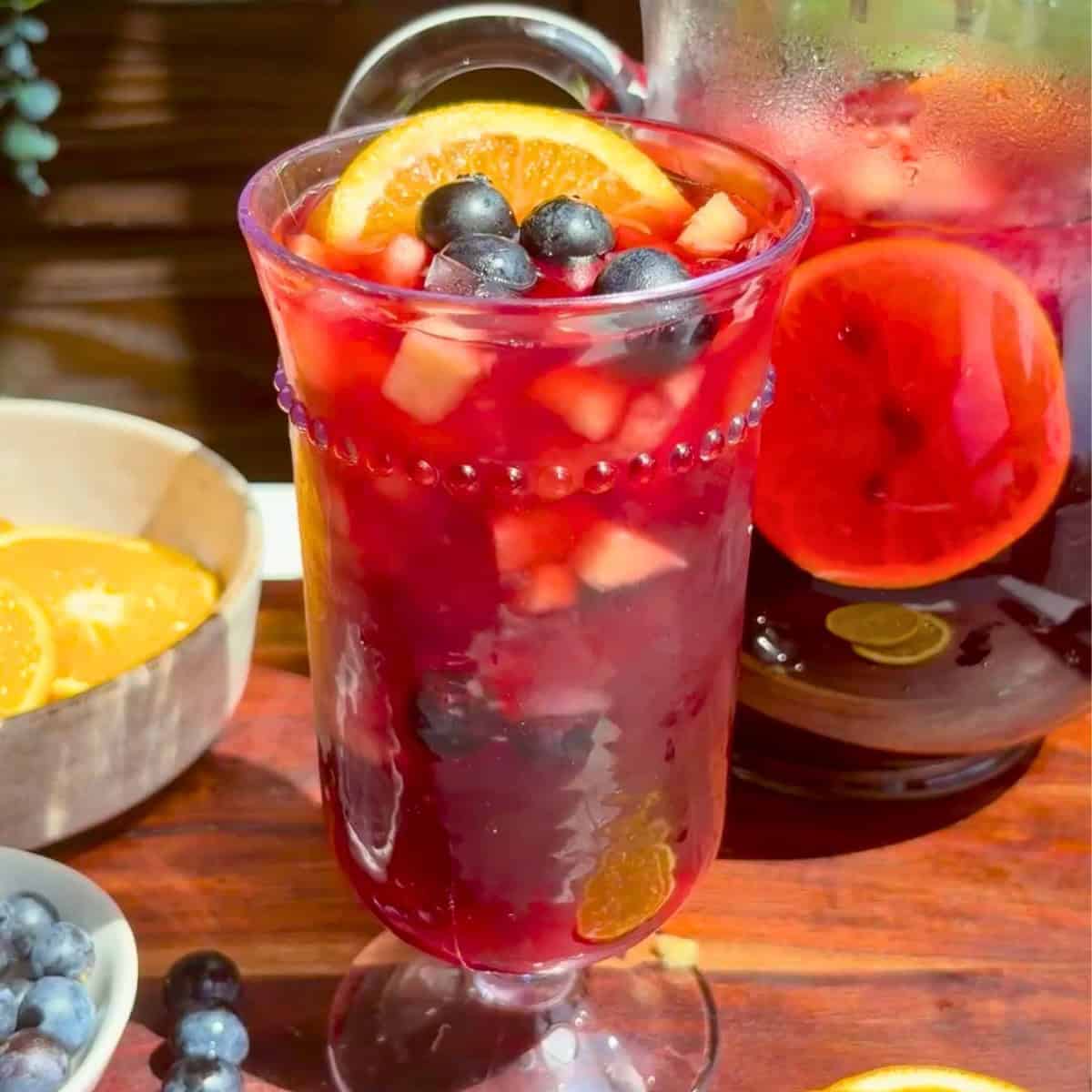 Pineapple hibiscus sun tea in a glass topped with fresh fruit.