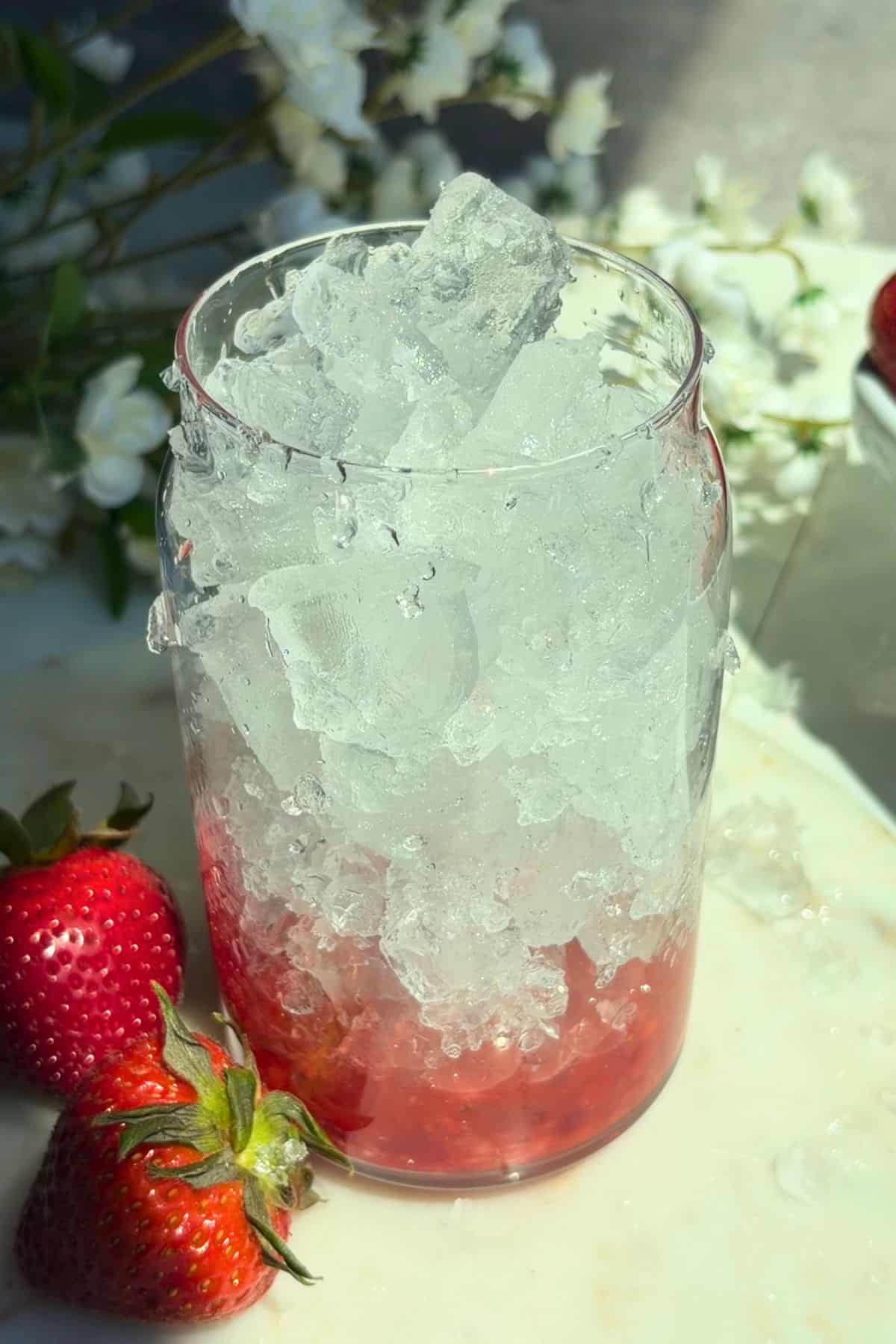Strawberry puree in a glass with ice.