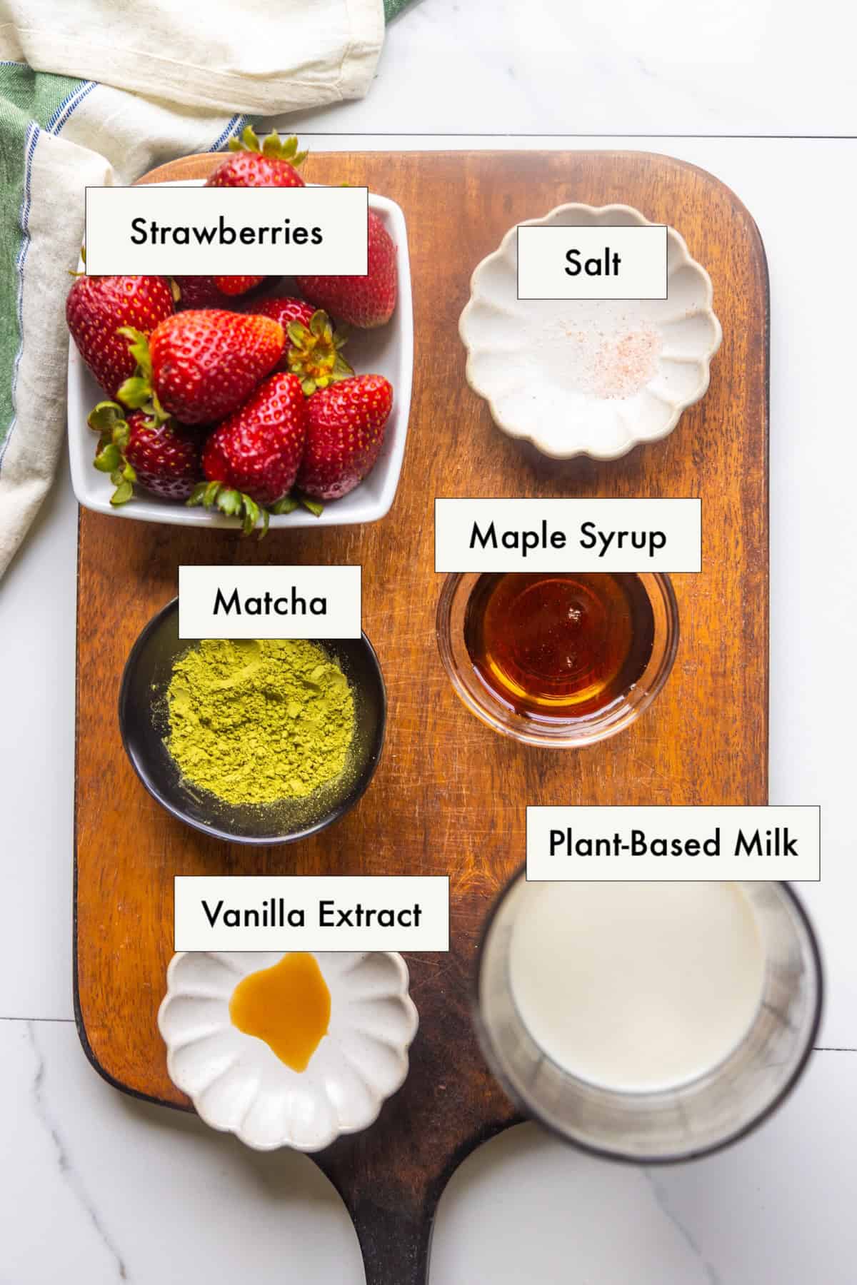 Ingredients for strawberry matcha latte laid out on a counter.