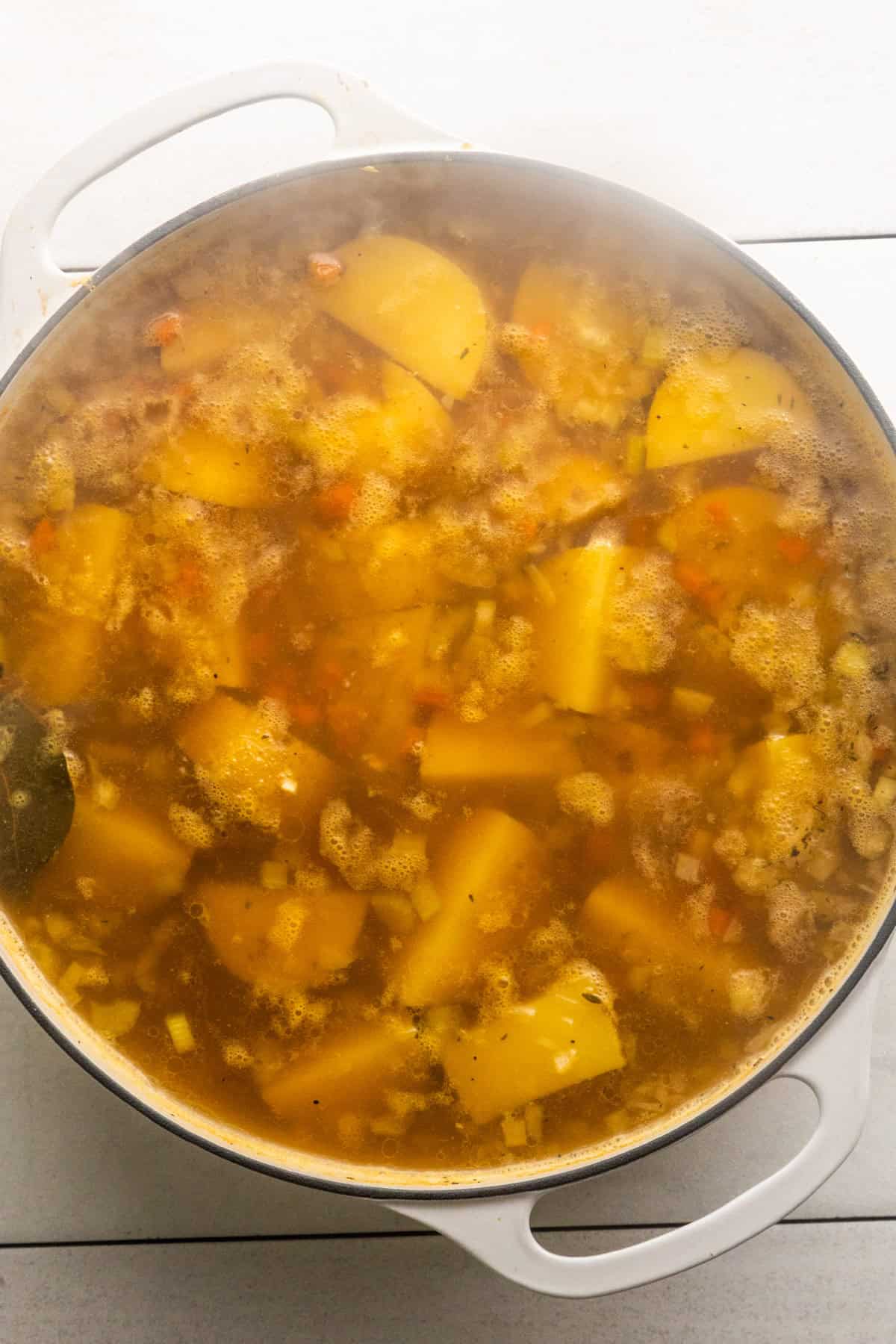 Mirepoix, potatoes, water, and seasonings in pot.
