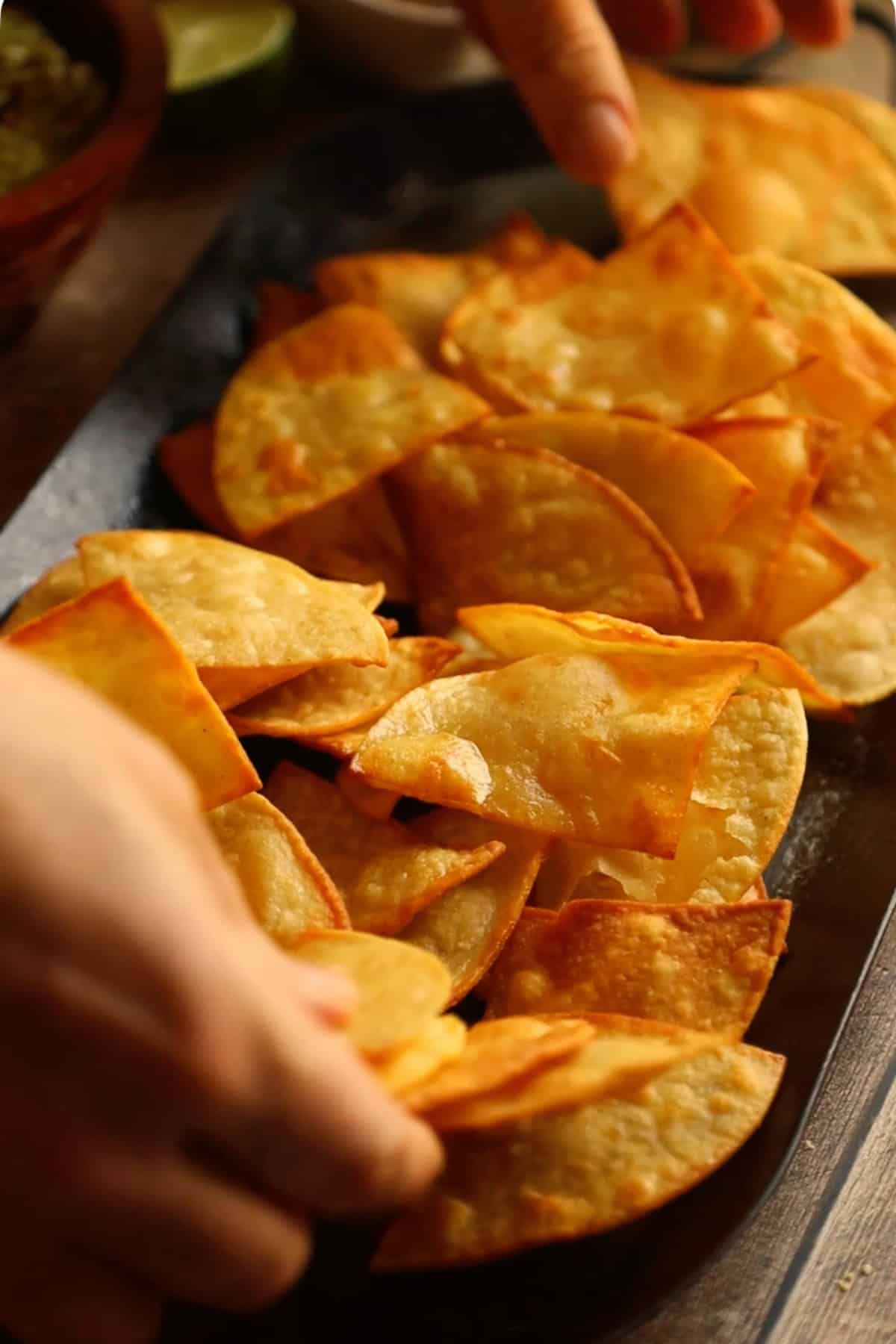 Tortilla chips spread out on a comal.